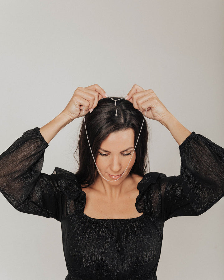 A woman lifting the Addie chain over her head